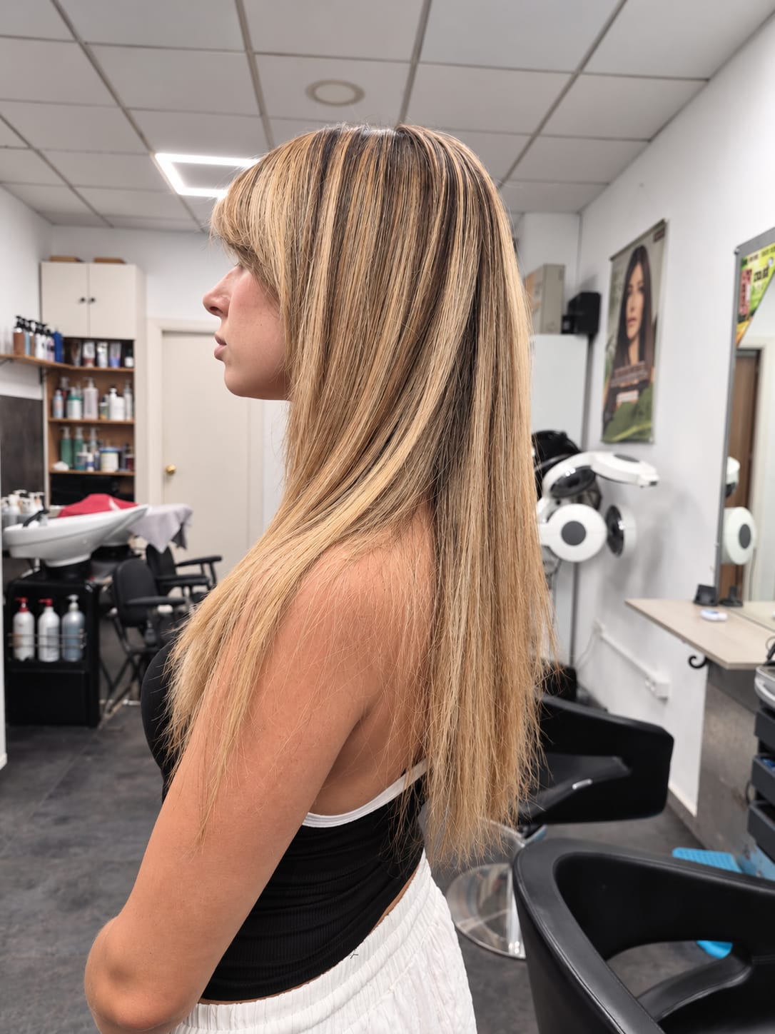 Melena larga con mechas rubias y flequillo, vista lateral